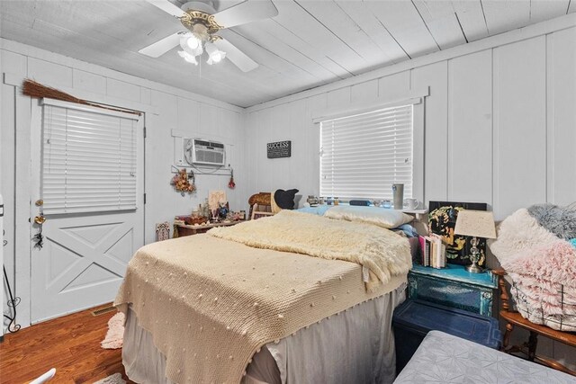 11 Glen Hollow Rd, Glen Carbon, IL 62034 - bedroom with wood finished floors, a wall mounted AC, a decorative wall, and a ceiling fan