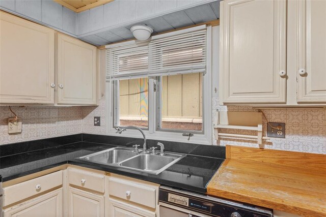 11 Glen Hollow Rd, Glen Carbon, IL 62034 - kitchen featuring dishwasher, a sink, decorative backsplash, and dark countertops