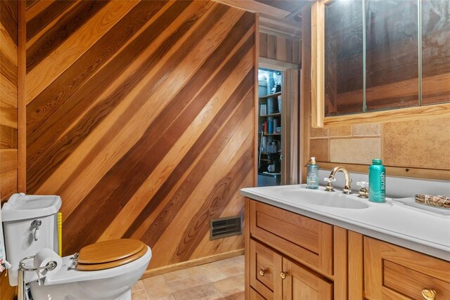 11 Glen Hollow Rd, Glen Carbon, IL 62034 - bathroom with wood walls, toilet, vanity, stone finish floors, and a bidet