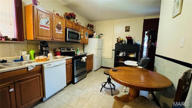 5044 Louisiana Ave, Saint Louis, MO 63111 - kitchen with stainless steel appliances, light countertops, brown cabinetry, light flooring, and a sink