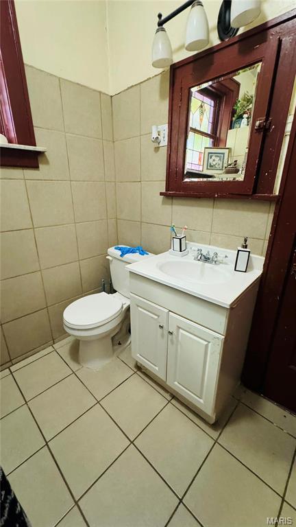 5044 Louisiana Ave, Saint Louis, MO 63111 - bathroom featuring tile walls, vanity, toilet, and tile patterned floors