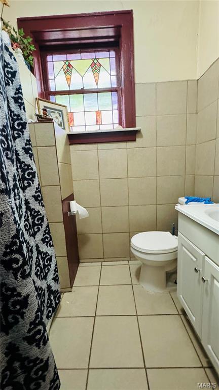 5044 Louisiana Ave, Saint Louis, MO 63111 - full bathroom with vanity, tile patterned floors, tile walls, toilet, and a shower with shower curtain