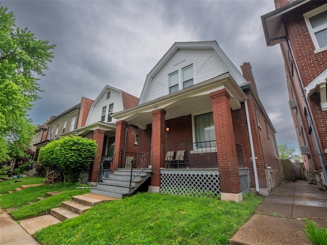 2614 Minnesota, Saint Louis, MO 63118 - view of front of property featuring brick siding, covered porch, a gambrel roof, and a front lawn