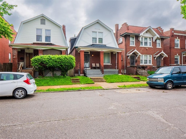 2614 Minnesota, Saint Louis, MO 63118 - colonial inspired home featuring a gambrel roof, a porch, and brick siding