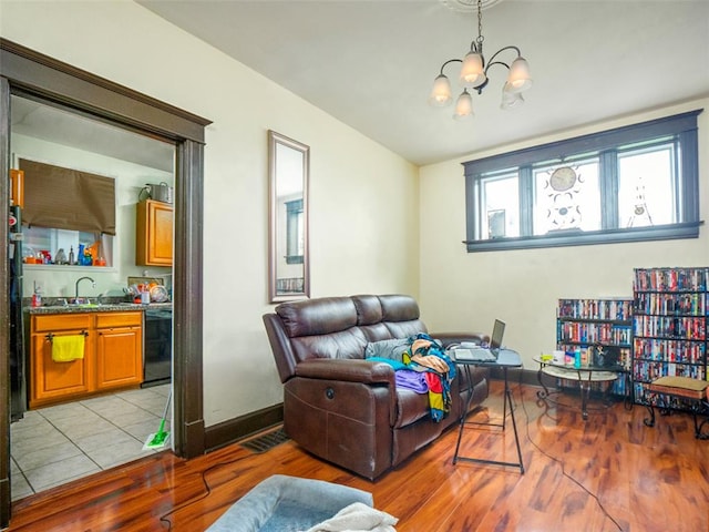 2614 Minnesota, Saint Louis, MO 63118 - living room with light wood-style flooring, a chandelier, and baseboards