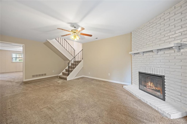 243 Mill Run Ln, Saint Peters, MO 63376 - unfurnished living room with a brick fireplace, a ceiling fan, carpet flooring, stairs, and baseboards
