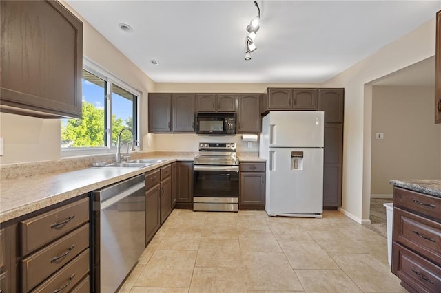 243 Mill Run Ln, Saint Peters, MO 63376 - kitchen with stainless steel appliances, a sink, track lighting, light countertops, and light tile patterned floors