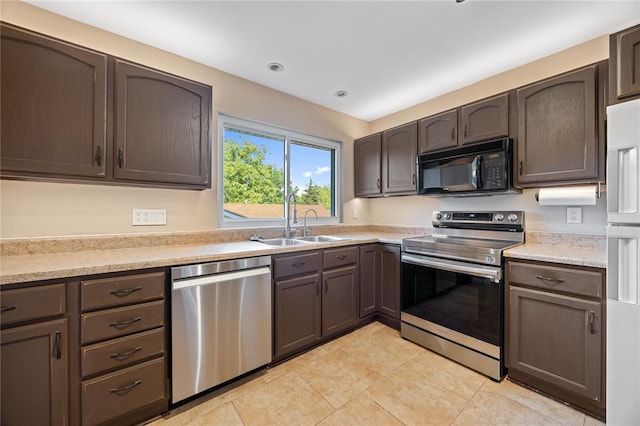 243 Mill Run Ln, Saint Peters, MO 63376 - kitchen with appliances with stainless steel finishes, a sink, light tile patterned floors, light countertops, and dark brown cabinetry