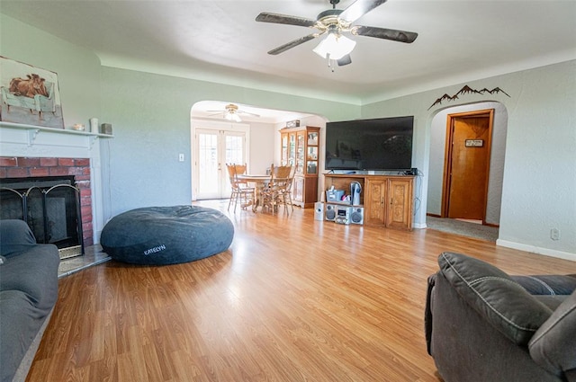 300 N Alvarado Ave, Belle, MO 65013 - living room with arched walkways, a ceiling fan, light wood-style floors, and a brick fireplace