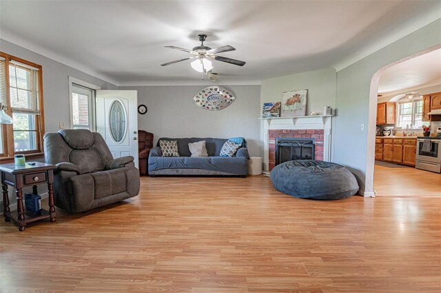300 N Alvarado Ave, Belle, MO 65013 - living room featuring ceiling fan, arched walkways, a fireplace, and light wood-style flooring