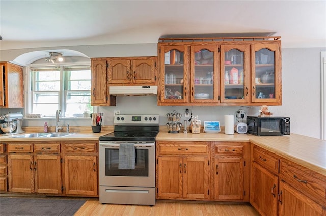 300 N Alvarado Ave, Belle, MO 65013 - kitchen with stainless steel range with electric cooktop, under cabinet range hood, black microwave, a sink, and brown cabinetry