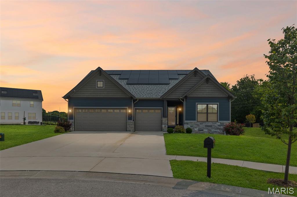 106 Potawatomi Ln, Ofallon, IL 62269 - view of front facade featuring a yard, driveway, solar panels, and a garage