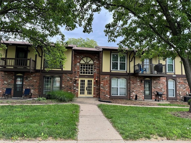 635 Rosetta Dr Unit D, Florissant, MO 63031 - view of front of home featuring french doors, a balcony, a front lawn, and stucco siding