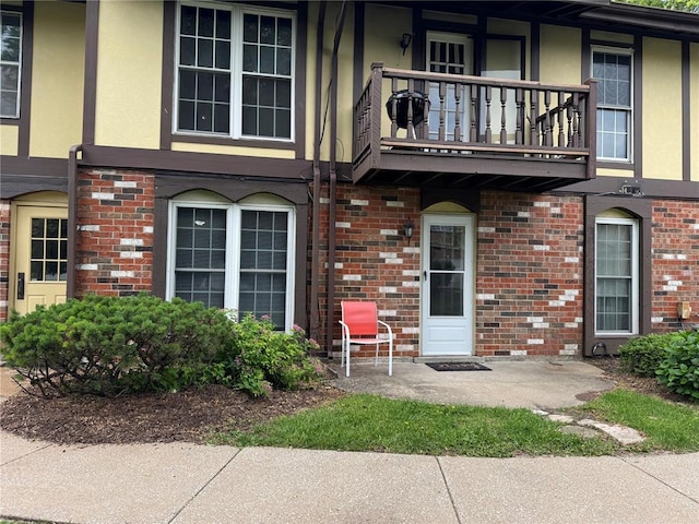 635 Rosetta Dr Unit D, Florissant, MO 63031 - property entrance with a balcony, brick siding, and stucco siding