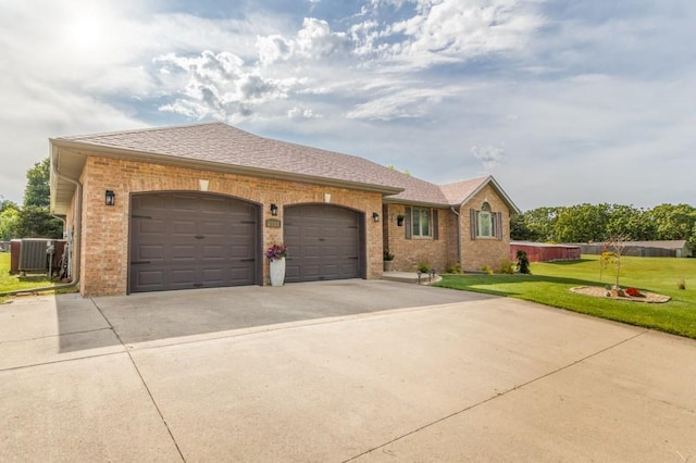2115 Tower Rd, Lebanon, MO 65536 - view of front of house featuring concrete driveway, brick siding, an attached garage, a front lawn, and central air condition unit