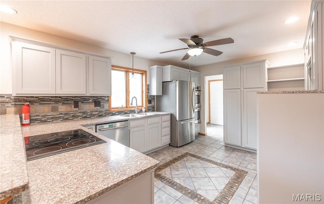 13399 S US Highway 63, Rolla, MO 65401 - kitchen with appliances with stainless steel finishes, ceiling fan, inlaid floor details, backsplash, and hanging light fixtures