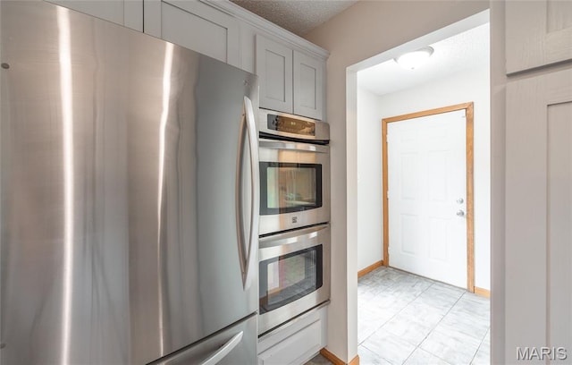 13399 S US Highway 63, Rolla, MO 65401 - kitchen featuring appliances with stainless steel finishes, gray cabinets, a textured ceiling, and baseboards