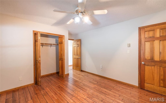 13399 S US Highway 63, Rolla, MO 65401 - unfurnished bedroom featuring light wood-style flooring, a closet, baseboards, a ceiling fan, and a textured ceiling