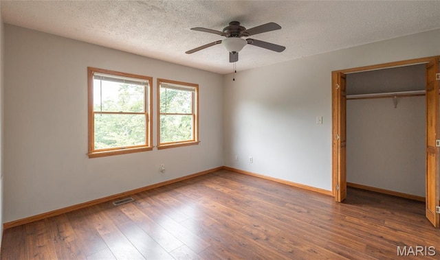 13399 S US Highway 63, Rolla, MO 65401 - unfurnished bedroom featuring baseboards, wood-type flooring, a closet, a textured ceiling, and a ceiling fan