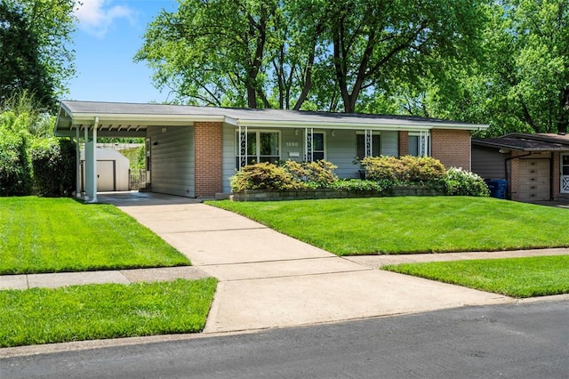 1090 Apache Dr, Florissant, MO 63033 - single story home with concrete driveway, a front yard, an attached carport, and brick siding