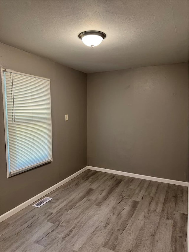 1341 Criterion Ave, Saint Louis, MO 63138 - unfurnished room with wood finished floors, baseboards, and a textured ceiling