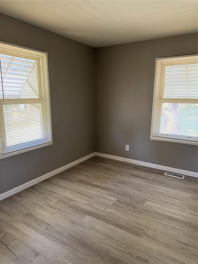 1341 Criterion Ave, Saint Louis, MO 63138 - unfurnished room featuring healthy amount of natural light, wood finished floors, and baseboards