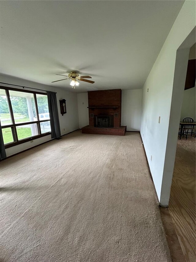 21008 W State Highway 47, Lonedell, MO 63060 - unfurnished living room with ceiling fan, carpet, a brick fireplace, and baseboards