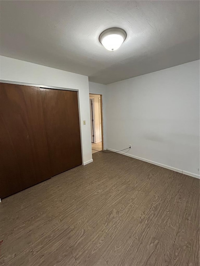 21008 W State Highway 47, Lonedell, MO 63060 - unfurnished bedroom featuring dark wood-style flooring, baseboards, and a closet