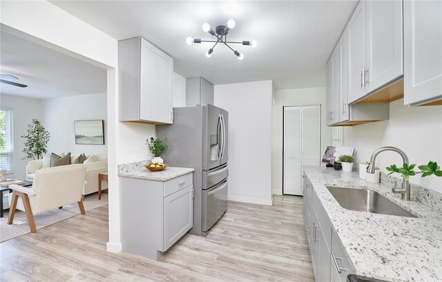 2613 Hillsboro Valley Park Rd, High Ridge, MO 63049 - kitchen featuring a sink, stainless steel fridge, light wood-style floors, a chandelier, and light stone counters
