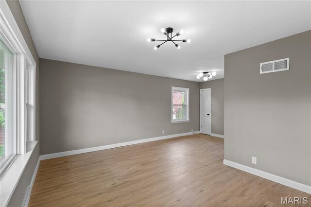 8364 Fullerton Ave, University City, MO 63132 - spare room with a chandelier and light wood-style flooring