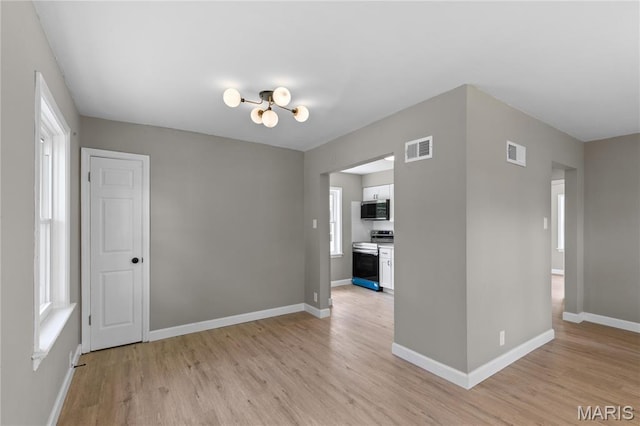 8364 Fullerton Ave, University City, MO 63132 - empty room featuring light wood finished floors and a chandelier