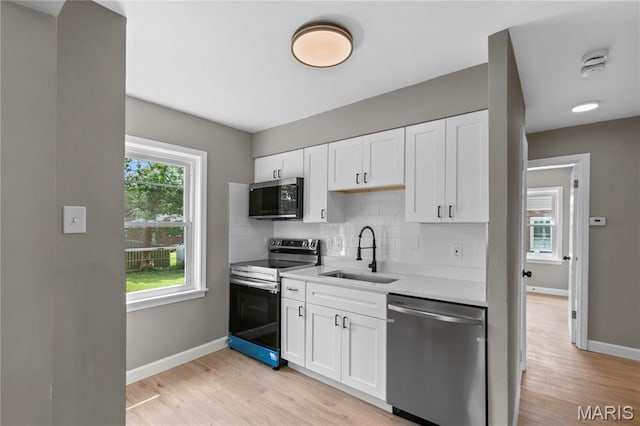 8364 Fullerton Ave, University City, MO 63132 - kitchen with stainless steel appliances, light wood-type flooring, backsplash, and light countertops