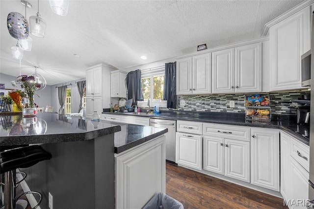 2850 S Hwy W, Winfield, MO 63389 - kitchen with stainless steel dishwasher, a textured ceiling, white cabinetry, a kitchen breakfast bar, and decorative backsplash