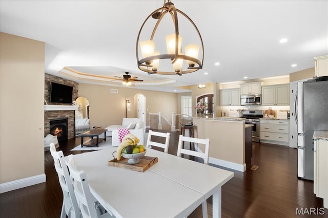 8743 Cardinal Creek Dr, Saint Jacob, IL 62281 - dining space featuring a ceiling fan, a tray ceiling, dark wood finished floors, a fireplace, and recessed lighting