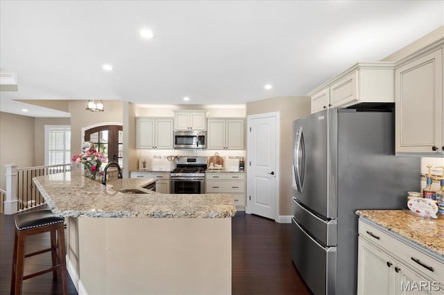 8743 Cardinal Creek Dr, Saint Jacob, IL 62281 - kitchen with stainless steel appliances, a sink, dark wood finished floors, light stone counters, and a spacious island