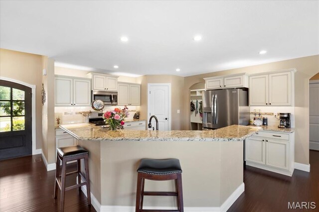 8743 Cardinal Creek Dr, Saint Jacob, IL 62281 - kitchen featuring stainless steel appliances, arched walkways, decorative backsplash, a kitchen breakfast bar, and recessed lighting
