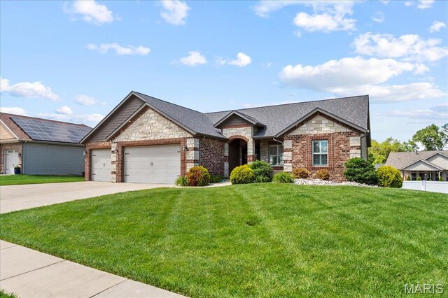 8743 Cardinal Creek Dr, Saint Jacob, IL 62281 - view of front of home featuring stone siding, an attached garage, a front yard, and concrete driveway