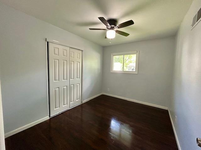 1157 June Ave, Saint Louis, MO 63138 - unfurnished bedroom with baseboards, dark wood finished floors, a closet, and ceiling fan
