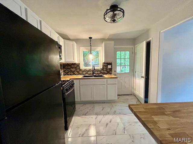 1157 June Ave, Saint Louis, MO 63138 - kitchen with black appliances, a sink, light marble finish flooring, white cabinets, and pendant lighting