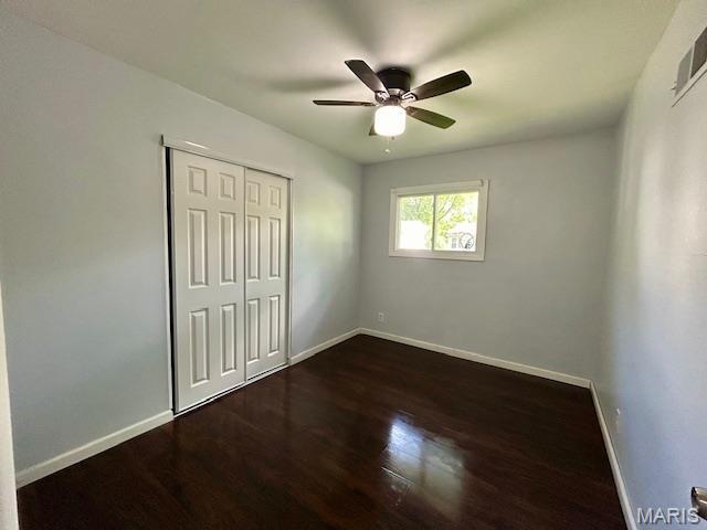 1157 June Ave, Saint Louis, MO 63138 - unfurnished bedroom with baseboards, dark wood-style flooring, a closet, and ceiling fan