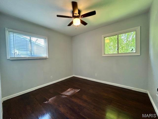 1157 June Ave, Saint Louis, MO 63138 - empty room with plenty of natural light, baseboards, and dark wood-style floors