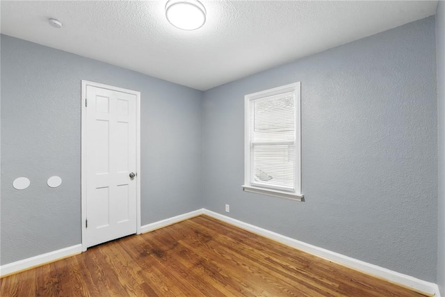 1901 Bainbridge Dr, Saint Louis, MO 63133 - empty room with wood finished floors, baseboards, and a textured wall