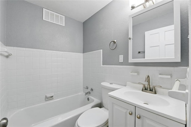 1901 Bainbridge Dr, Saint Louis, MO 63133 - bathroom with a tub to relax in, toilet, vanity, a textured wall, and tile walls
