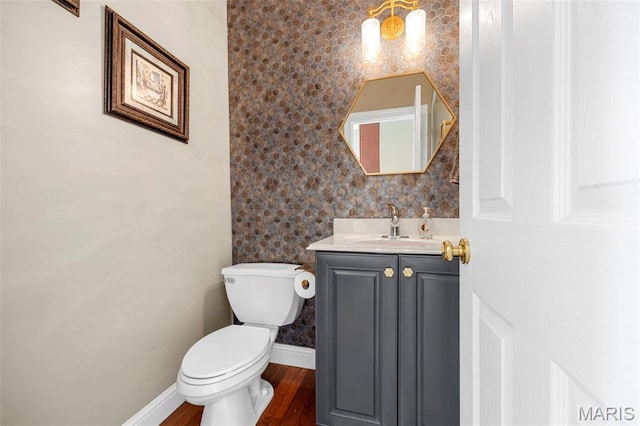 102 Riparian Dr, Ofallon, MO 63368 - half bathroom with vanity, toilet, wood finished floors, wallpapered walls, and baseboards