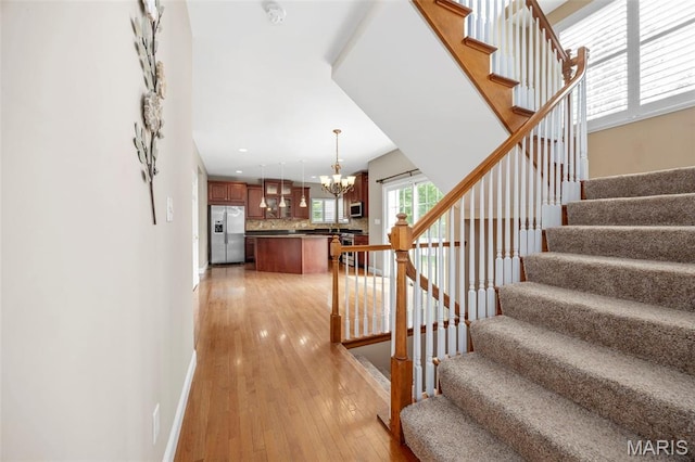 102 Riparian Dr, Ofallon, MO 63368 - stairs featuring a chandelier, hardwood / wood-style flooring, baseboards, and recessed lighting
