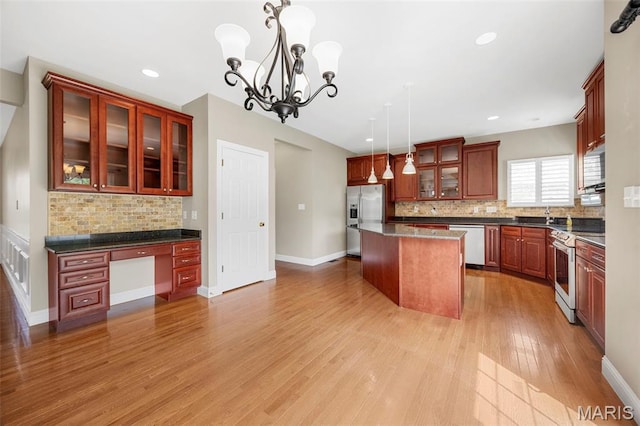 102 Riparian Dr, Ofallon, MO 63368 - kitchen featuring appliances with stainless steel finishes, tasteful backsplash, light wood-type flooring, a kitchen island, and a chandelier