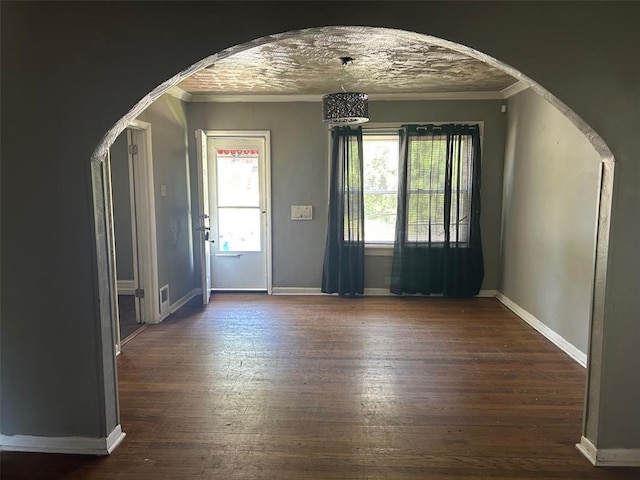 3838 Avondale Ave, Northwoods, MO 63121 - foyer with arched walkways, ornamental molding, dark wood-style floors, and baseboards
