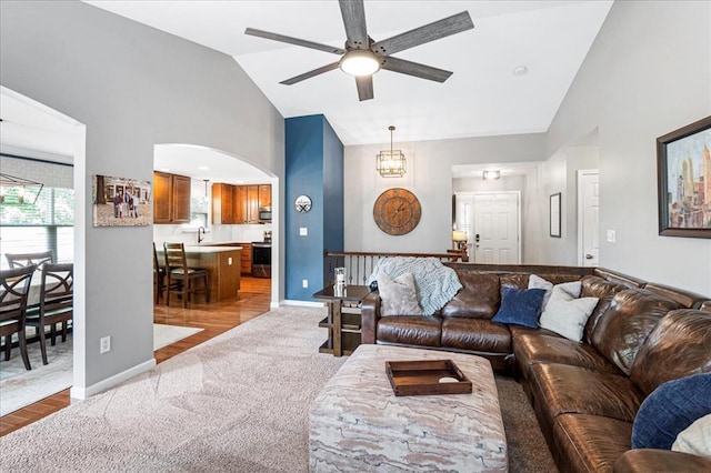 1456 Red Oak Plantation Dr, Ballwin, MO 63021 - carpeted living area with ceiling fan, high vaulted ceiling, baseboards, arched walkways, and wood finished floors