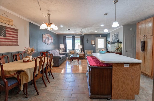 606 N Charles Ave, St James, MO 65559 - kitchen with crown molding, a center island, a textured ceiling, stone tile flooring, and light countertops