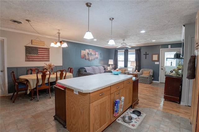 606 N Charles Ave, St James, MO 65559 - kitchen featuring crown molding, light countertops, a textured ceiling, open floor plan, and pendant lighting